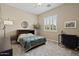 Bright bedroom features a ceiling fan, a full bed, a window with white shutters, and a comfortable chair at 42 S Nevada Way, Gilbert, AZ 85233