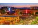 Vibrant downtown scene featuring colorful buildings, outdoor dining, string lights, and a backdrop of scenic mountains at dusk at 42 S Nevada Way, Gilbert, AZ 85233