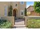 Elegant entryway with a wooden front door and gate, framed by manicured landscaping at 42 S Nevada Way, Gilbert, AZ 85233