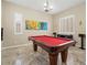 Bright game room with a red pool table, plantation shutters, and ample space for entertainment at 42 S Nevada Way, Gilbert, AZ 85233