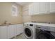 A functional laundry room with modern washer, dryer and cabinet space at 42 S Nevada Way, Gilbert, AZ 85233