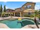 Beautiful pool with a tanning shelf, surrounded by lush landscaping and backyard patio at 42 S Nevada Way, Gilbert, AZ 85233