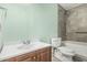 Well-maintained bathroom featuring a tub shower, toilet, and vanity with sink and wood cabinets at 421 S 113Th Way, Mesa, AZ 85208
