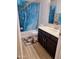Bathroom featuring a single sink vanity, shower-tub combination with blue curtain, and wood-look flooring at 421 S 113Th Way, Mesa, AZ 85208