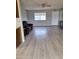Open living room with wood-look floors, neutral paint, and a window providing ample natural light at 421 S 113Th Way, Mesa, AZ 85208
