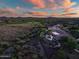 Stunning aerial sunset view of home, pool, and neighborhood golf course at 42429 N Cross Timbers Ct, Anthem, AZ 85086