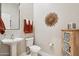 Powder bathroom featuring pedestal sink, decorative sunburst wall art, and decorative wood cabinet at 42429 N Cross Timbers Ct, Anthem, AZ 85086