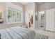 Bedroom showcasing tile floors, a walk-in closet, an en-suite bathroom, and window with shutters at 42429 N Cross Timbers Ct, Anthem, AZ 85086