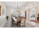 Formal dining room featuring a large wood table, stylish chandelier, and neutral color palette at 42429 N Cross Timbers Ct, Anthem, AZ 85086