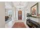 Grand foyer with a striking chandelier, elegant decor, and a view of the dining room with shutters at 42429 N Cross Timbers Ct, Anthem, AZ 85086