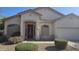 Charming single-story home featuring a well-manicured yard, neutral tones, and a lovely red front door at 43634 W Roth Rd, Maricopa, AZ 85138