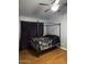Cozy bedroom with a dark canopy bed, gray walls, and natural light at 520 N Stapley Dr # 265, Mesa, AZ 85203
