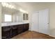 Primary bathroom featuring a dual sink vanity, large mirror, and walk-in closet at 5223 W Bent Tree Dr, Phoenix, AZ 85083