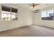 Bright bedroom featuring neutral walls, carpet flooring, and natural light from two windows at 5223 W Bent Tree Dr, Phoenix, AZ 85083