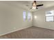 Neutral bedroom featuring carpeted floors, bright windows, and ceiling fan at 5223 W Bent Tree Dr, Phoenix, AZ 85083
