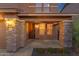 Inviting front porch with stone pillars and warm lighting, creating a welcoming entrance at 5223 W Bent Tree Dr, Phoenix, AZ 85083