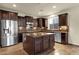 Open-concept kitchen with stainless steel appliances, a center island, and dark wood cabinetry at 5223 W Bent Tree Dr, Phoenix, AZ 85083