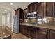 Modern kitchen featuring stainless steel appliances, granite countertops, and dark wood cabinetry at 5223 W Bent Tree Dr, Phoenix, AZ 85083