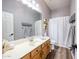 Bathroom boasts wood-look flooring, a large mirror, a shower with curtain, and vanity storage at 5416 W Village Dr, Glendale, AZ 85308