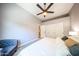 Bright bedroom features a ceiling fan, chair, neutral walls, and a view into the bathroom at 5416 W Village Dr, Glendale, AZ 85308