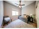 Neutral toned bedroom featuring a ceiling fan, daybed, and a side chair at 5416 W Village Dr, Glendale, AZ 85308