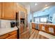 Kitchen boasts stainless steel appliances, wood cabinets, counterspace and a view into the living room at 5416 W Village Dr, Glendale, AZ 85308