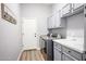 Well-lit laundry room with machines, cabinets, white countertops and a view to the exterior at 5416 W Village Dr, Glendale, AZ 85308