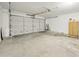 Spacious garage featuring bare concrete flooring and an automatic overhead door at 5602 N 73Rd Ave, Glendale, AZ 85303