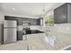 Renovated kitchen featuring granite countertops, stainless appliances, and a stylish lighting fixture at 5602 N 73Rd Ave, Glendale, AZ 85303