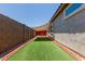 Enclosed backyard area with artificial grass and shade covering, providing a private outdoor space at 5659 N 195Th Dr, Litchfield Park, AZ 85340