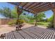 Backyard featuring covered patio, desert landscaping, privacy fence, and lush greenery at 5659 N 195Th Dr, Litchfield Park, AZ 85340