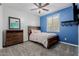 Cozy bedroom featuring a blue accent wall, white trim, gray carpet, and a ceiling fan at 5659 N 195Th Dr, Litchfield Park, AZ 85340