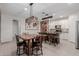 Open kitchen with a wooden table with seating and an island with breakfast bar stools at 5659 N 195Th Dr, Litchfield Park, AZ 85340