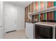Functional laundry room features modern washer and dryer set and colorful accent wall at 5659 N 195Th Dr, Litchfield Park, AZ 85340