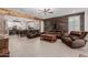 Spacious living room with comfortable leather seating, wood accents, and an open layout to the kitchen at 5659 N 195Th Dr, Litchfield Park, AZ 85340