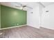 Spacious bedroom with contemporary ceiling fan, wood-look flooring, and green accent wall at 620 S Allred Dr, Tempe, AZ 85288