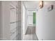 Well-lit hallway with vinyl flooring and built-in glass shelving for storage at 620 S Allred Dr, Tempe, AZ 85288