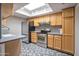 Updated kitchen featuring stainless steel appliances, granite counters, tile backsplash, and skylight at 620 S Allred Dr, Tempe, AZ 85288