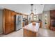 Well-equipped kitchen with stainless steel appliances, central island, wood cabinetry, and stylish pendant lighting at 6715 S Lakeshore Dr, Tempe, AZ 85283
