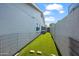 Narrow side yard with artificial turf, enclosed with a fence, and a view of the house at 6715 S Lakeshore Dr, Tempe, AZ 85283