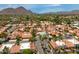 Scenic aerial view of a community with lush greenery, mountain views, multiple pools, and red-tiled roofs at 7115 E Buena Terra Way, Paradise Valley, AZ 85253