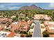 Stunning aerial view showcasing the property's neighborhood, mature palm trees, and scenic mountain backdrop at 7115 E Buena Terra Way, Paradise Valley, AZ 85253