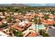 Stunning aerial view of a community with red-tiled roofs, lush palm trees, a sparkling pool, and mountain views at 7115 E Buena Terra Way, Paradise Valley, AZ 85253