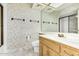 Well-lit bathroom featuring a modern vanity, decorative wallpaper, and a shower with glass doors at 7115 E Buena Terra Way, Paradise Valley, AZ 85253
