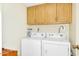 Functional laundry room featuring a white washer and dryer and wooden cabinets for storage at 7115 E Buena Terra Way, Paradise Valley, AZ 85253