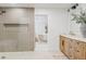 Modern bathroom featuring walk in shower, bright vanity, and an open doorway to the main bedroom at 7409 E Pleasant Run, Scottsdale, AZ 85258