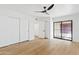 This is an empty bedroom with white walls, wood floors, a ceiling fan, and an entrance to the balcony at 7409 E Pleasant Run, Scottsdale, AZ 85258