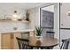 Charming breakfast nook features a round wooden table and stylish decor, lit by a modern wall sconce at 7409 E Pleasant Run, Scottsdale, AZ 85258