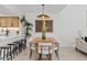 Bright eat in kitchen features a long, wooden dining table, a large pendant light, and seating at the kitchen island at 7409 E Pleasant Run, Scottsdale, AZ 85258