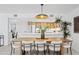 Kitchen and dining area with light wood cabinets and an extra large pendant light at 7409 E Pleasant Run, Scottsdale, AZ 85258